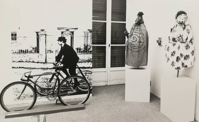 Spazio espositivo con manichini e un ciclista d'epoca