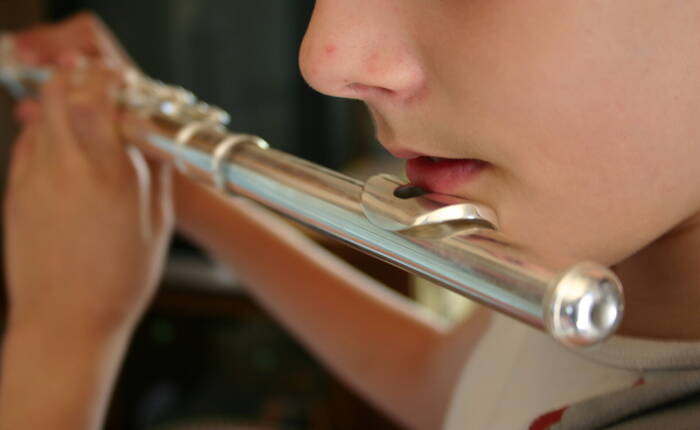 partcolare di viso di bimba che suona il flauto