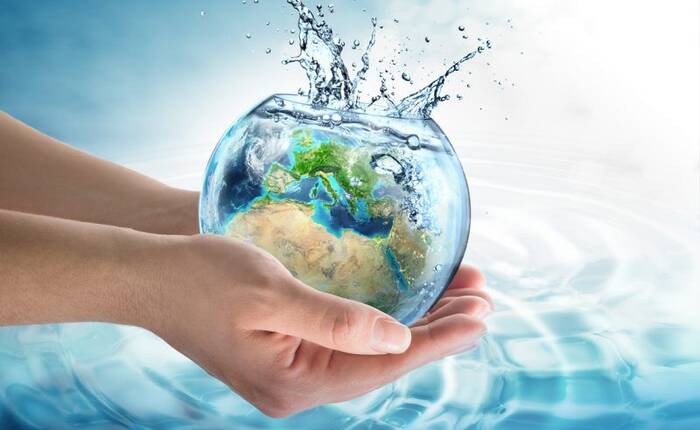 2 mani tengono un vaso d'acqua con raffigurato il mondo in trasparenza