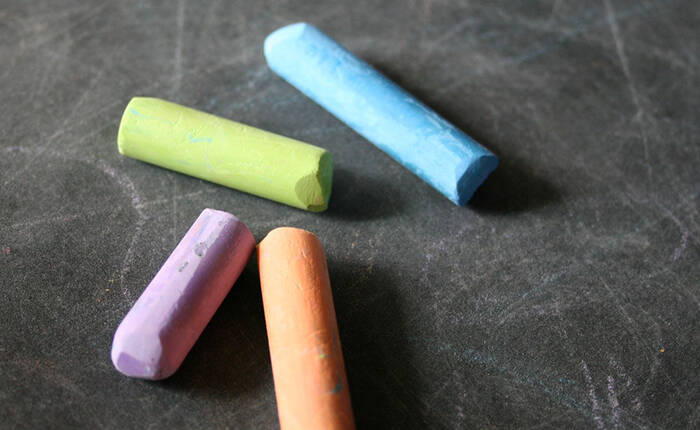 Gessi colorati appoggiati su una lavagna