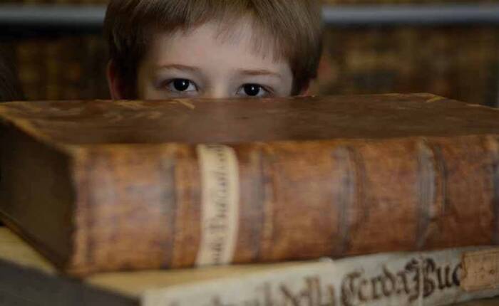 bimbo che osserva nascosto da una pila di libri antichi (foto Stefania Pocchi 2014)