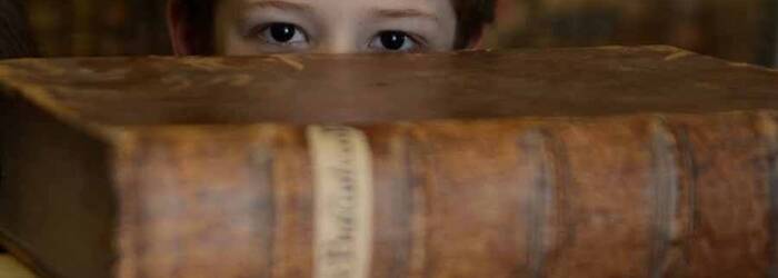 bimbo che osserva nascosto da una pila di libri antichi (foto Stefania Pocchi 2014)