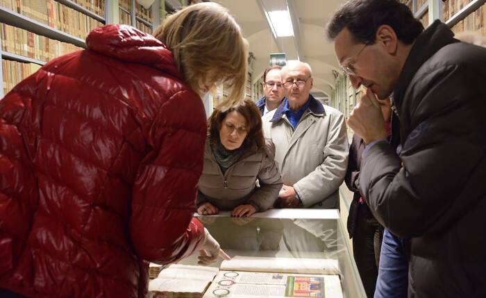 Adulti in visita guidata ai magazzini osservano una vetrina espositiva (Foto Florio Badocchi 2014)