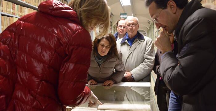Adulti in visita guidata ai magazzini osservano una vetrina espositiva (Foto Florio Badocchi 2014)