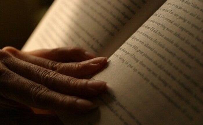 mano che regge un libro aperto