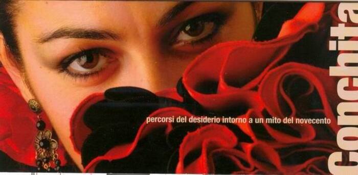 Volantino Conchita con viso di donna spagnoleggiante in primo piano su fondo rosso