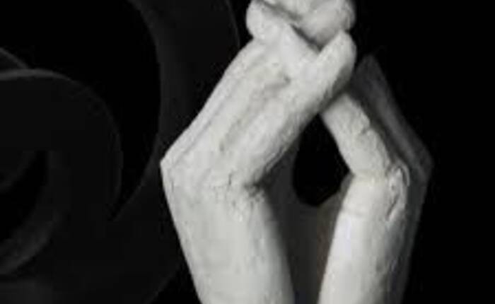 immagine che riproduce l'opera esposta, due grandi mani giunte