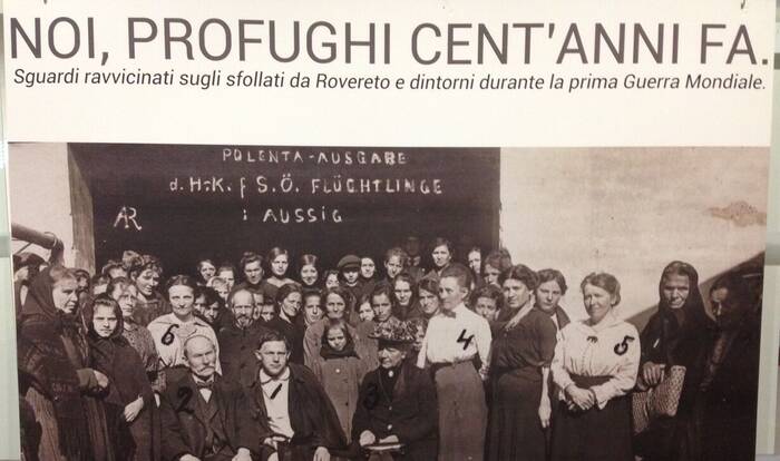 Manifesto della mostra con gruppo di profughi