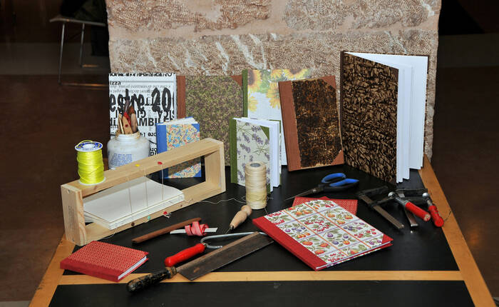 Libri rilegati a mano, morsetti, seghetto, torchio e attrezzatura varia per la rilegatura artigianale (Foto Florio Badocchi 2012)