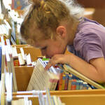 zona bambini - bimba che cerca tra i libri (foto Florio Badocchi 2014)